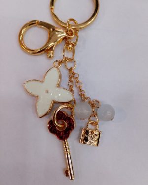 LLAVERO CON DIJES DE FLOR, LLAVE Y BOLITAS$95
